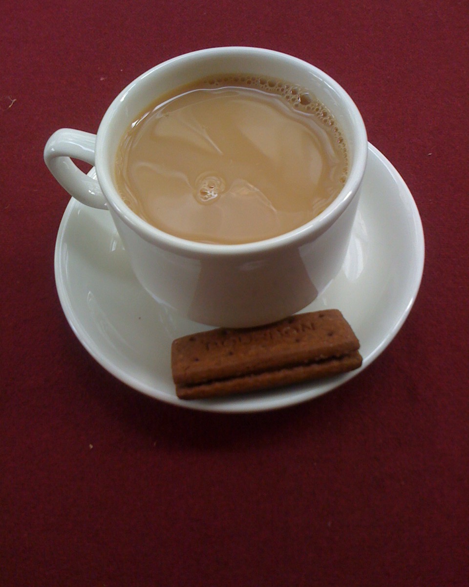 A cup of tea with a bourbon biscuit